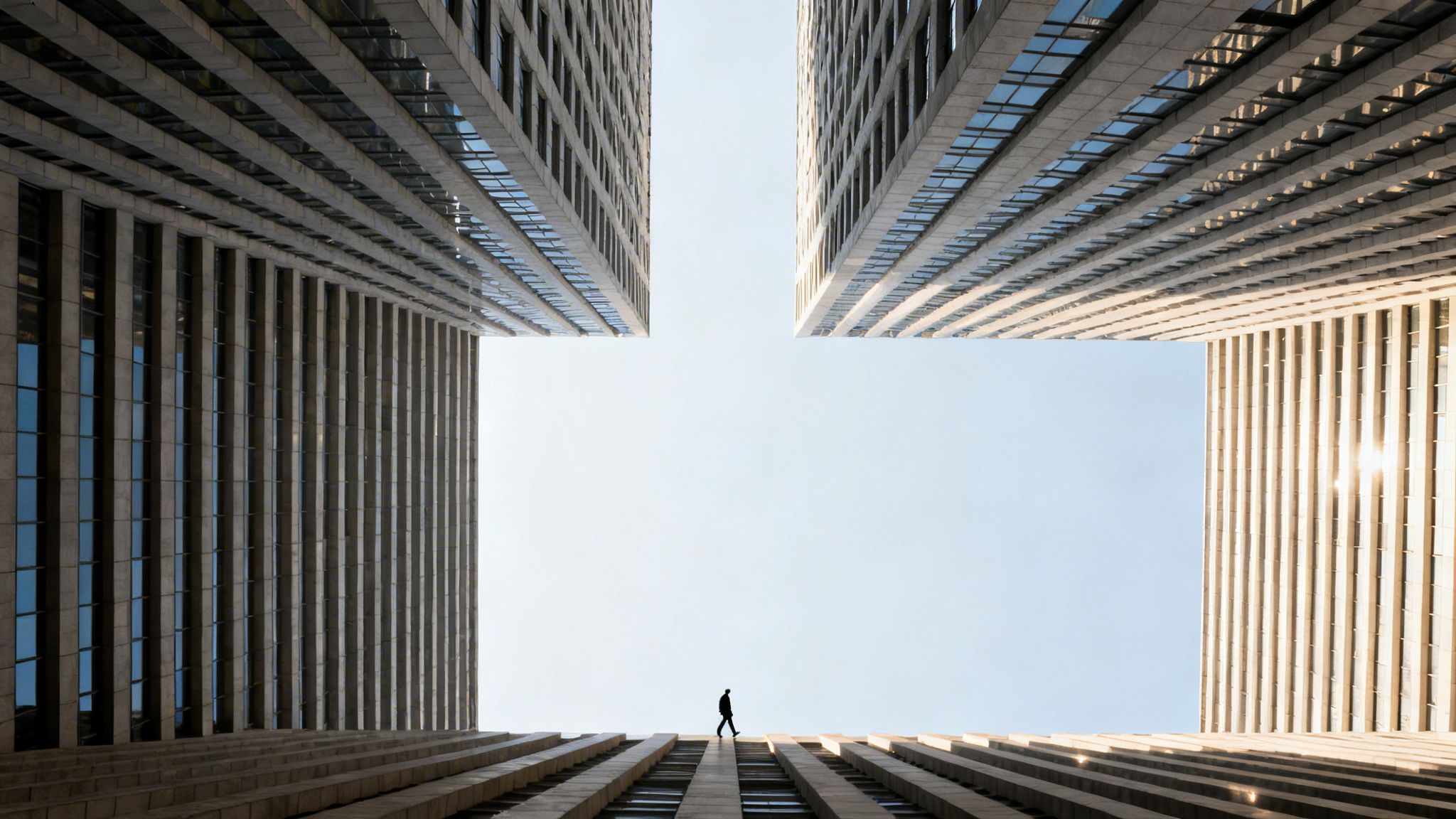A lone figure walks across a geometric rooftop, framed by towering skyscrapers under a clear sky.