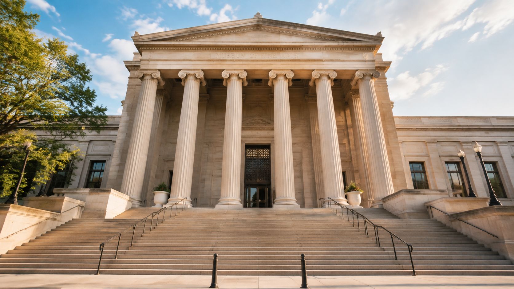A grand, neoclassical museum building featuring tall white columns and a wide set of stone stairs.